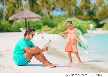 Little girl and happy dad having fun during beach vacation Little girl and happy dad having fun during beach vacation 60890309