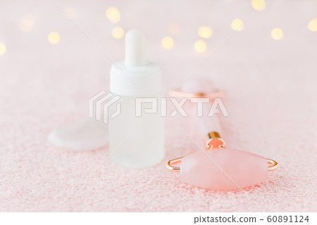 real rose quartz facial roller, gua sha massage stone and face serum, selective focus 60891124