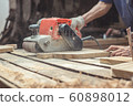 Carpenter sanding wood with belt sander at workshop in wooden cutting board project or woodworking carpentry 60898012