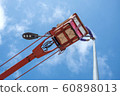 Technician on bucket truck high up of a crane to fix street light. 60898013