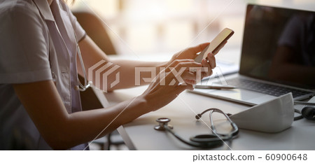 Cropped shot of young female doctor using Cropped shot of young female doctor using 60900648