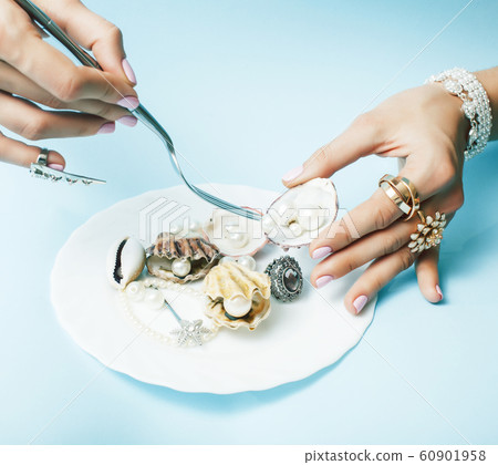 beautiful woman hands with pink manicure holding plate with pearls and sea shells, luxury jewelry concept beautiful woman hands with pink manicure holding plate with pearls and sea shells, luxury jewelry concept 60901958