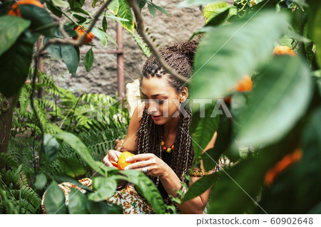 pretty islam woman in orange grove smiling, real muslim girl cheerful , nature organic people concept 60902648
