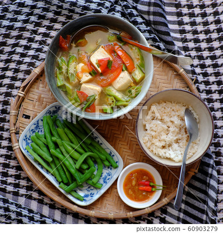vegan food menu with boiled peas, bowl of okra, tomato, tofu soup and rice 60903279