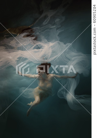 Girl in a white dress with a cloth swims underwater Girl in a white dress with a cloth swims underwater 60905284
