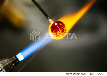 Close-up of glass bead melting in gas-burner fire Close-up of glass bead melting in gas-burner fire 60905552