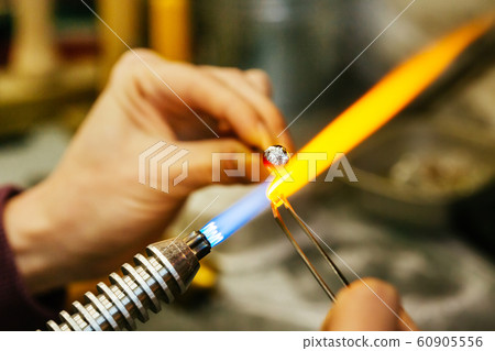 Close-up of glass bead melting in gas-burner Close-up of glass bead melting in gas-burner 60905556