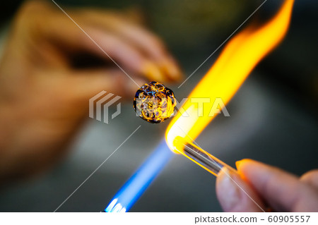 Close-up of glass bead melting in gas-burner fire Close-up of glass bead melting in gas-burner fire 60905557