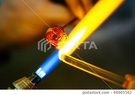 Close-up of glass bead melting in gas-burner fire Close-up of glass bead melting in gas-burner fire 60905562