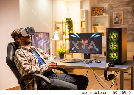 Professional gamer man using VR headset to play on powerful PC Professional gamer man using VR headset to play on powerful PC 60906900