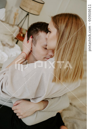 Close-up portrait of a beautiful young couple hugs in bed at home Close-up portrait of a beautiful young couple hugs in bed at home 60908611