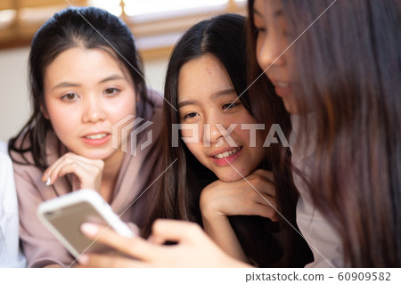 Group of cheerful women using smartphone shopping 60909582