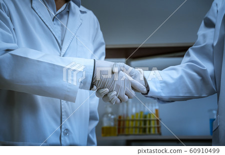 Scientists shake hands together to symbolize Scientists shake hands together to symbolize 60910499