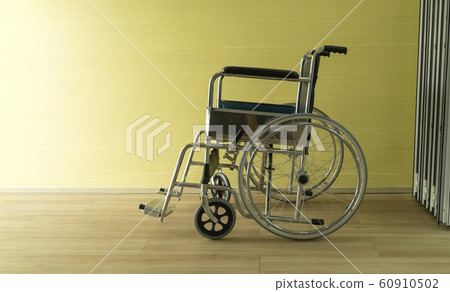 Wheelchair is parked in a room with a yellow wall 60910502