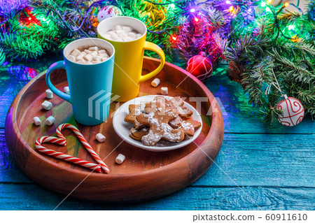 Image of New Year cookies, cookies, two mugs of cocoa with marshmallows, caramel sticks, branches of spruce 60911610