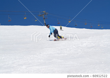 Snowboarder descends on snowy ski slope at winter 60912522