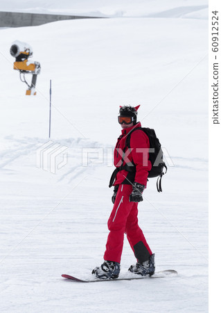 Snowboarder in red on snowy ski slope Snowboarder in red on snowy ski slope 60912524