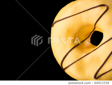Glazed donut with sprinkles on a black background Glazed donut with sprinkles on a black background 60913356