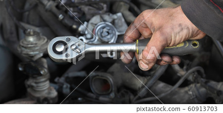 Socket wrench tool in mechanic hand 60913703