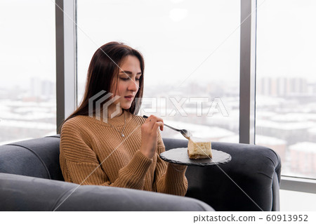 girl eating a cake while sitting in a chair in 60913952