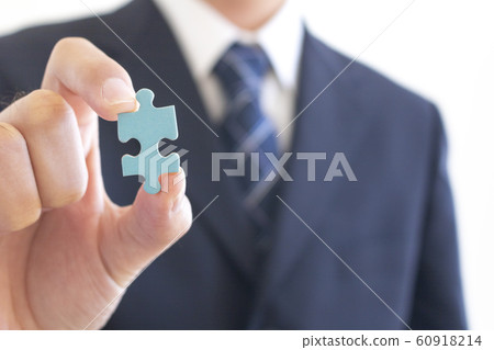 Men in suits holding jigsaw puzzle pieces Men in suits holding jigsaw puzzle pieces 60918214
