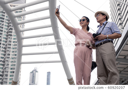 Senior Asian couple selfie by mobile outdoors. 60920207