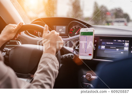 hands of a woman on a steering wheel of a car 60920887