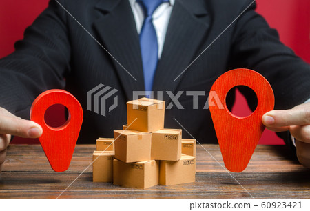 A businessman sets a destination for goods delivery. Global market and business, import and export. Trade in new markets. Distribution, freight transportation shipment. Logistics and warehousing. A businessman sets a destination for goods delivery. Global market and business, import and export. Trade in new markets. Distribution, freight transportation shipment. Logistics and warehousing. 60923421