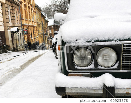 Car getting covered with snow during snow storm. 60925878