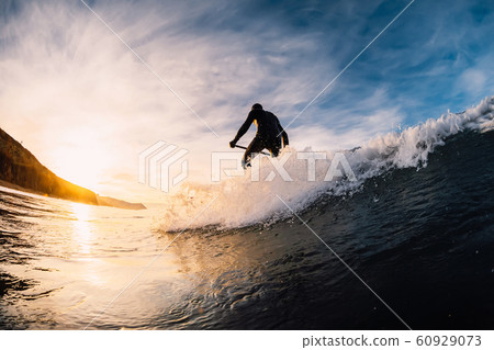 Stand Up Paddle surfing on waves. SUP board and surfer in wetsuit in morning Stand Up Paddle surfing on waves. SUP board and surfer in wetsuit in morning 60929073