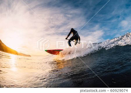 Stand Up Paddle surfing on waves. SUP board and surfer in wetsuit in morning 60929074