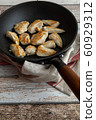 Roasted chicken breast in antique looking frying pan on wooden table, high angle view 60929312