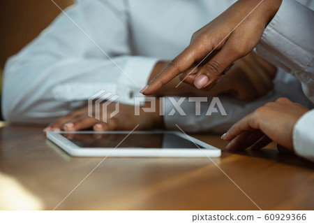 Close up of african-american human's hands using tablet on wooden table 60929366
