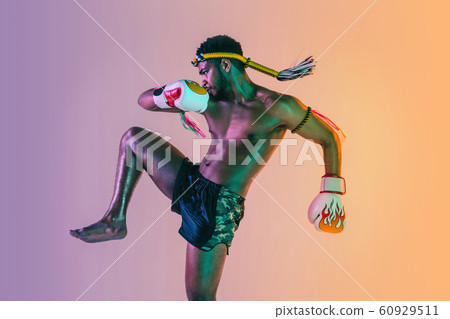 Muay thai. Young man exercising thai boxing on gradient background 60929511
