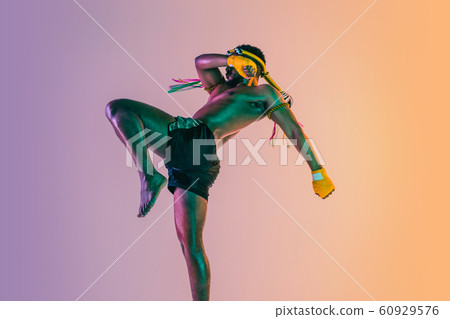 Muay thai. Young man exercising thai boxing on gradient background Muay thai. Young man exercising thai boxing on gradient background 60929576
