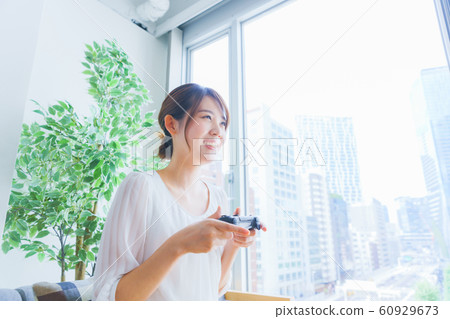 A woman enjoying a game at a home party Japanese lifestyle living salon matching room A woman enjoying a game at a home party Japanese lifestyle living salon matching room 60929673