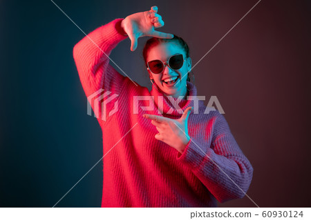 Caucasian woman's portrait isolated on gradient studio background in neon light 60930124