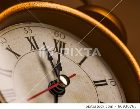 Golden vintage alarm clock showing five to twelve Golden vintage alarm clock showing five to twelve 60930765