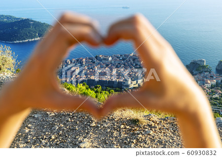 View of Dubrovnik through women's heart-shaped hands. Croatia, Europe 60930832