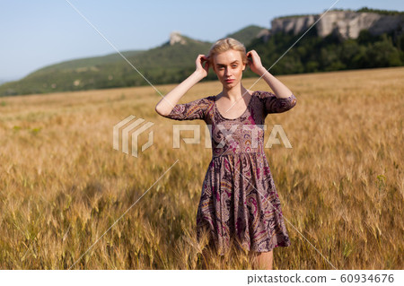 portrait of a beautiful fashionable blonde woman in a hat in a field of ripe wheat 60934676