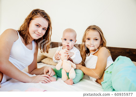 three girls sisters in the play in the bedroom in the morning love 60935977