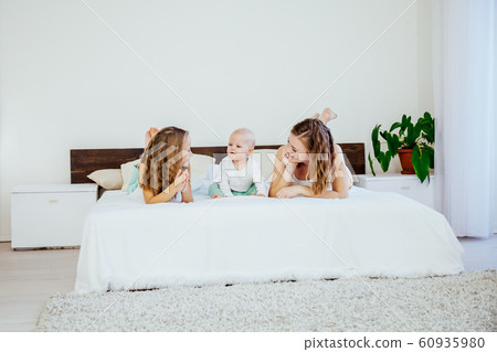 three girls sisters in the play in the bedroom in the morning love 60935980
