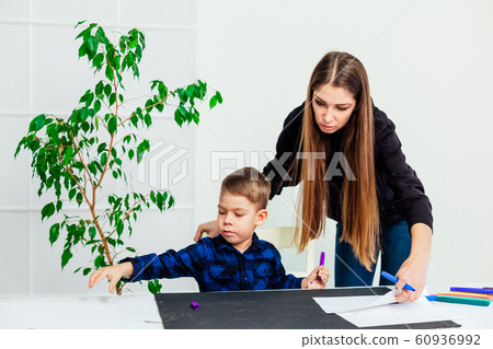 mom teaches young boy son to draw markers at the table mom teaches young boy son to draw markers at the table 60936992