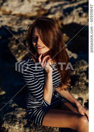 Portrait of a girl in a striped dress and long hair 60939047