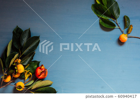 autumn red and yellow leaves of the fruit pomegranate persimmon 60940417