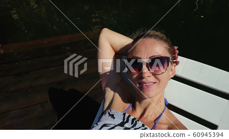 Woman shooting self portrait. Take photo and video on smartphone. Girl rest, relax, walk in sunglasses, make selfie. Blogger broadcast video vlogging. Woman shooting self portrait. Take photo and video on smartphone. Girl rest, relax, walk in sunglasses, make selfie. Blogger broadcast video vlogging. 60945394