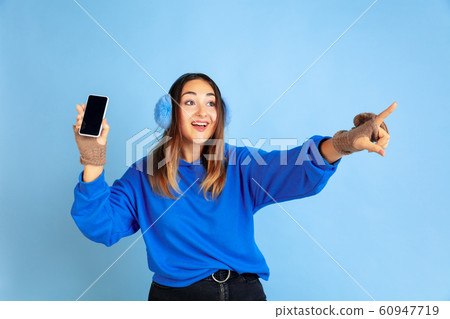 Caucasian woman's portrait isolated on blue studio background, winter theme 60947719