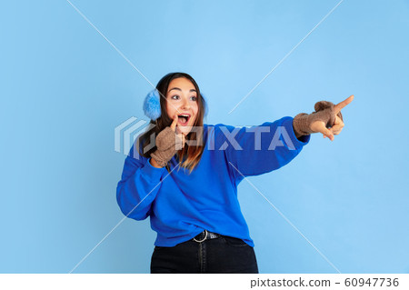 Caucasian woman's portrait isolated on blue studio background, winter theme 60947736