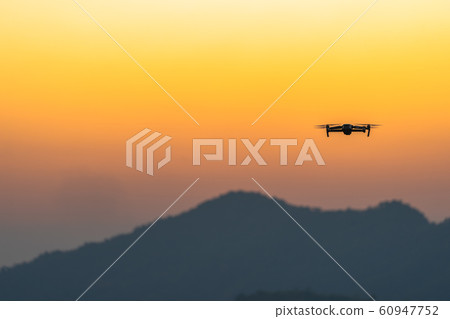 Drone flying in sunset on hilltop 60947752