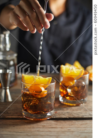 Tasty alcoholic old fashioned cocktail with orange Tasty alcoholic old fashioned cocktail with orange 60949450